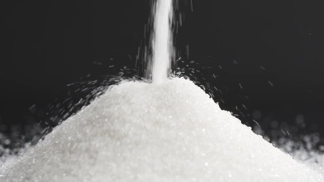 Slow motion of white sugar falling on black background, 180fps prores footage