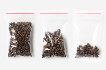 Set of three EMPTY, HALF AND FULL Plastic transparent zipper bag with coffee beans isolated on white. Vacuum package mockup with red clip. Concept