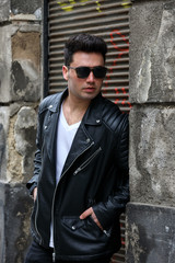 Naklejka premium Handsome young man with sunglasses and black leather jacket