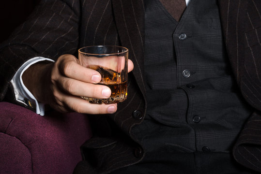 Closeup of serious businessman holding whiskey illustrate executive privilege concept