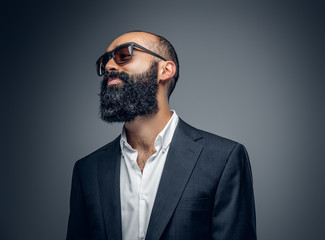 Bald head male dressed in a suit and sunglasses.