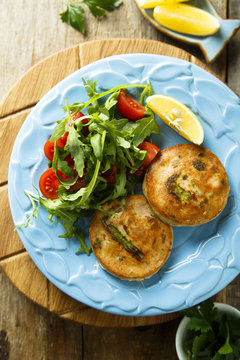 Salmon cakes with vegetables and arugula salad
