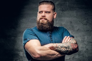 Bearded fat male with tattoo on arms.