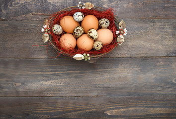 Easter eggs in a basket on a vintage wooden background