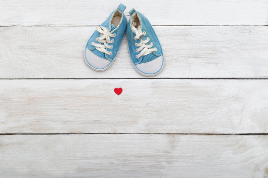 Blue Shoes For A Small Baby On A Wooden Background. View From Above