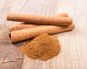 Cinnamon sticks on wooden background.
