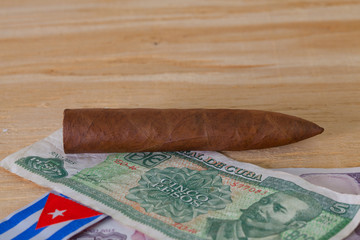 Luxury Cuban cigars and money on the wooden desk