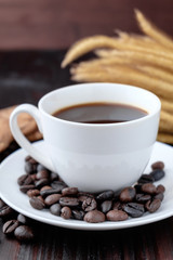 Coffee cup and coffee beans on wooden background