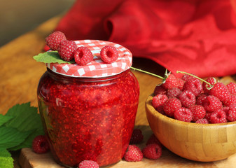 Raspberry jam and fresh raspberry on a rustic wooden table
