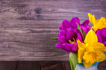 fresh purple tulip, yellow flowers close up on wooden background Bouquet snowdrops on wooden background. Spring flowers. Mother's Day, Valentines Day, Women's Day. Copyspace.