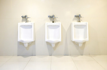 three white chamber pot on the wall in the rest room.