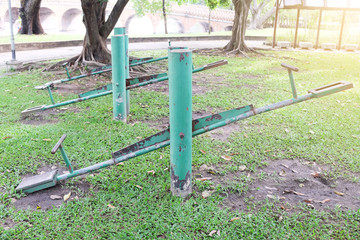 old green swing in the public park with orange light