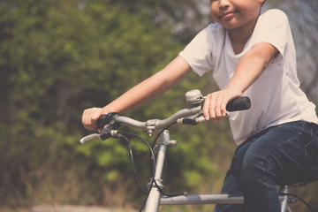 Obraz premium Little boy ride bicycle on the rock road.