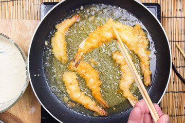 Chef frying shrimp Tempura with chopsticks
