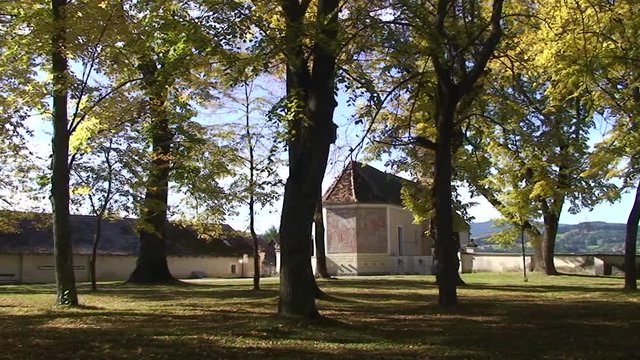 Herbstliche Lindenb&auml;ume - im Hintergrund die Friedhofsmauer und Friedhofskapelle von Vorau (horizontaler Kameraschwenk)