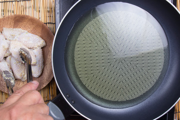 Chef putting chicken wings for fring in pan