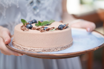 hands holding delicious creamy cake