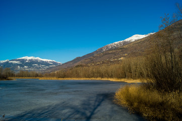 Fototapeta na wymiar mountain panorama, with frozen lake, trees and forest