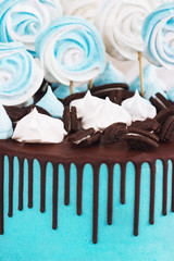 Children's blue cake rainbow color on a white background with meringue