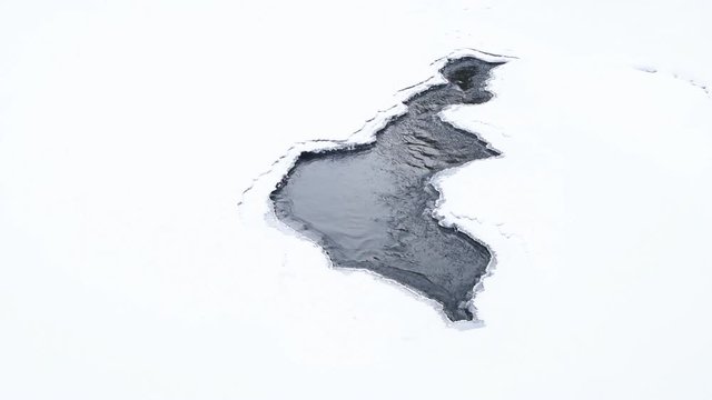 thawed patch of ice. Spring river has washed out the ice.
