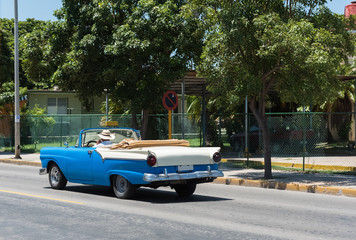 Hübscher blau weißer Cabriolet Oldtimer fährt auf der Straße in Varadero Kuba - Serie Kuba Reportage