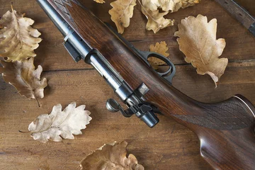 Photo sur Aluminium Chasser carabine de chasse et feuilles de chêne sur fond de bois vue de dessus