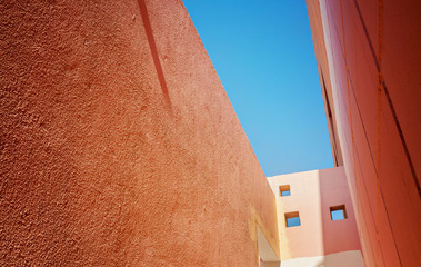 view of the sky from a narrow passage between the orange houses