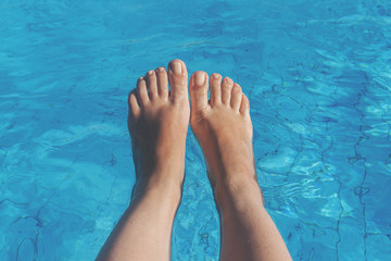 naked female legs on a background of blue water