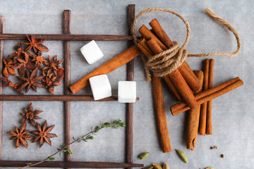 Spices and ingredients for aromatic sweet hot drinks - anise or aniseed, cinnamon bark, cardamom seeds, white sugar cbes, thyme twig.
