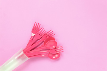 Top view colorful plastic spoon on pink table background with copy space.