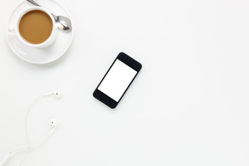 Top view  accessories office desk.smartphones earphones and cup of coffee on white background.