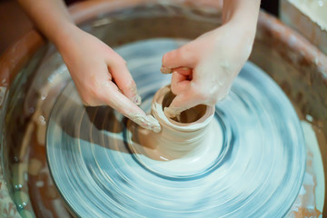 Hands of the child clinging clay pot. Master class on clay modeling. Modeling of pottery on the potter's wheel.