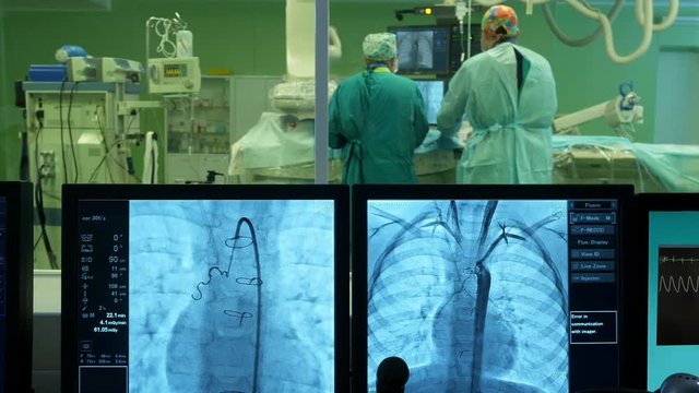 Surgeons make angiographic cardio surgery. View from the control room