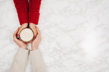 Couple in love holding hands with coffee on white marble table. Photograph taken from above, top view with copy space