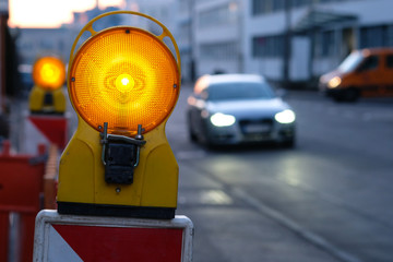 Baustellenleuchte und Auto mit Scheinwerfer