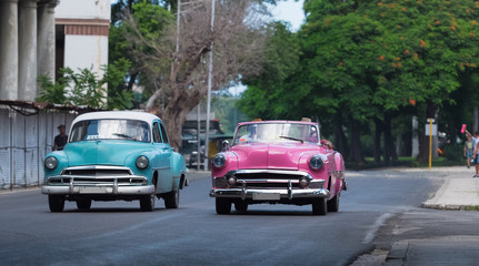 Auf der Hauptstrasse in Havanna Kuba fahrende amerikanische blauer und pinker Cabriolet Oldtimer - Serie Kuba Reportage