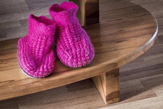 Purple soft knitted slippers lay on the step.
