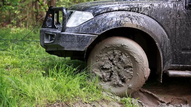 Black SUV got stuck in the mud in the forest, off-road