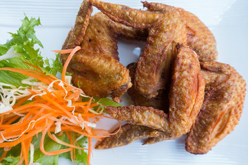 Chichen wing fried with salad in white dish on wooden table