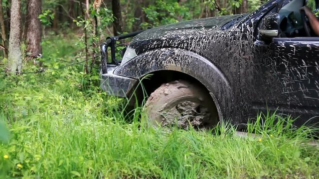 Black SUV got stuck in the mud in the forest, off-road