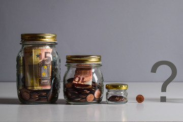 glass jar of different sizes full of money