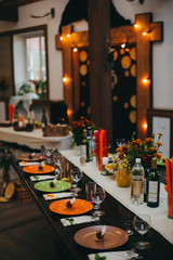Wedding banquet table with dishes, vine and food. Loft, country and rustic style. Decoration. Arch with bulb garland on background