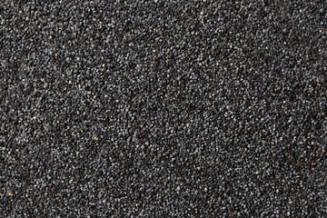 background of dark dry raw poppy seeds background.