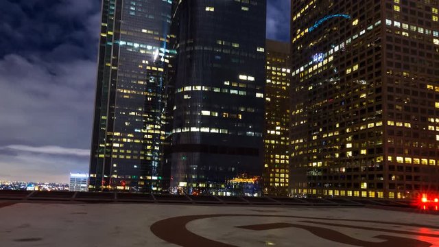 MoCo Tracking Timelapse of LA Skyline over Rooftop Helipad at Night -Zoom Out-