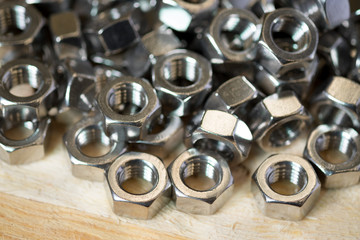 Steel nuts on wooden background