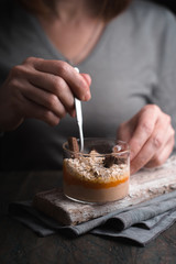 Woman in a gray cardigan eats a banana smoothie with oatmeal