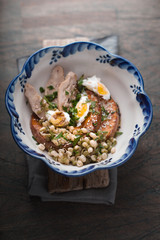 Salad with chicken, pumpkin, beans and quail eggs in a bowl top view