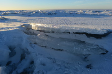 Desert ice floe to ice floe to the horizon line in the light of the morning sun