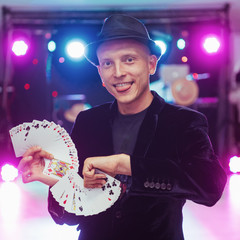 Magician showing trick with playing cards. Magic, circus