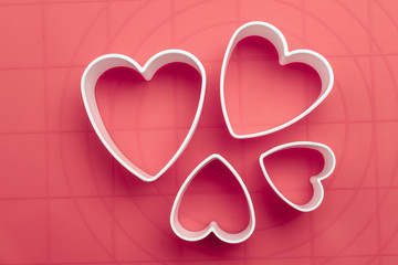 White heart shape cookie cutters on baking mat